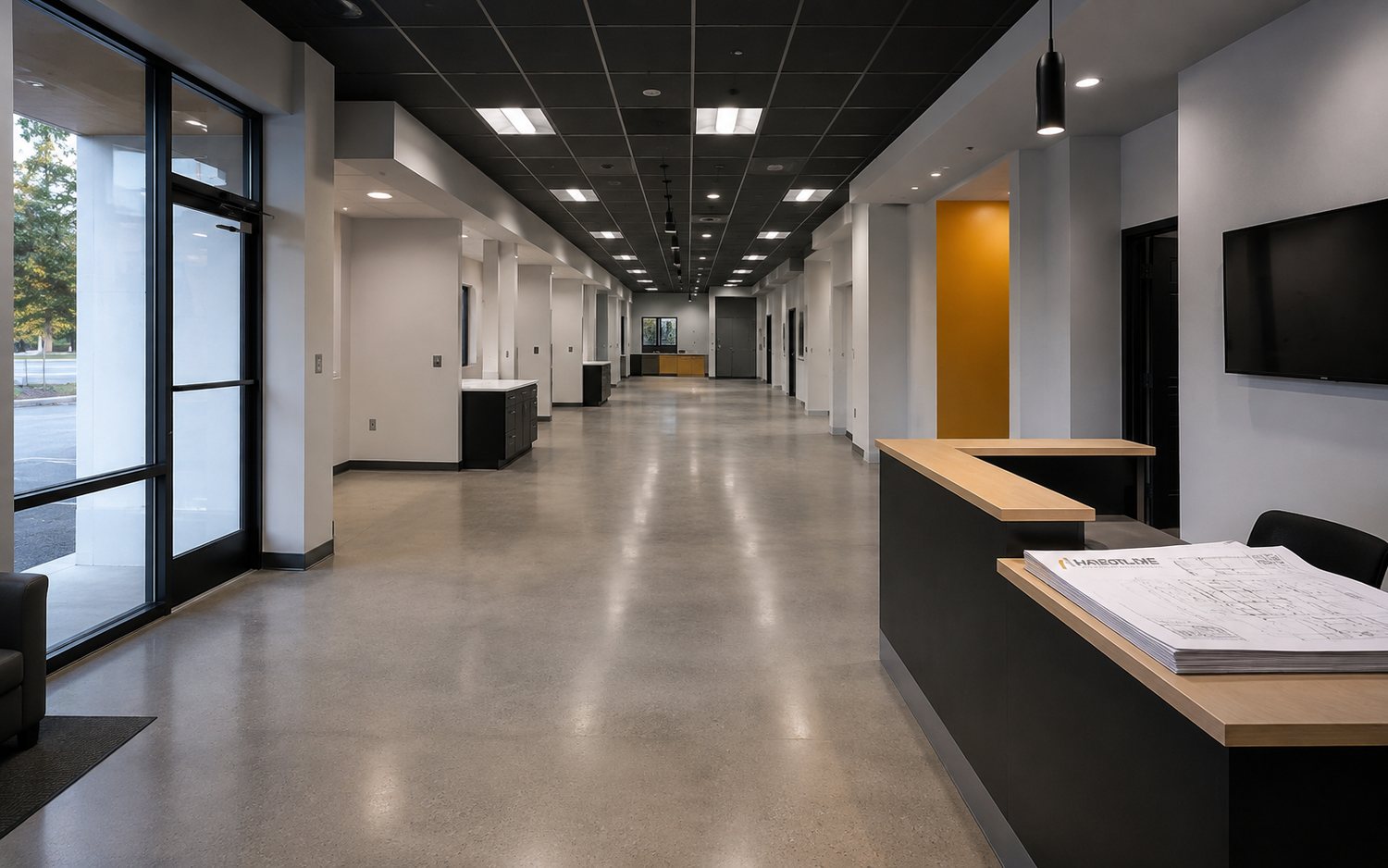 Completed multi-site clinic interior with repeating treatment bays, suspended ceiling grid and polished concrete floor